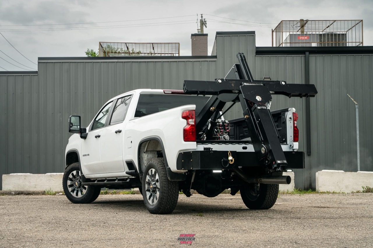 Baby Gladiator in-bed wheel lift stowed on a white Chevrolet pickup